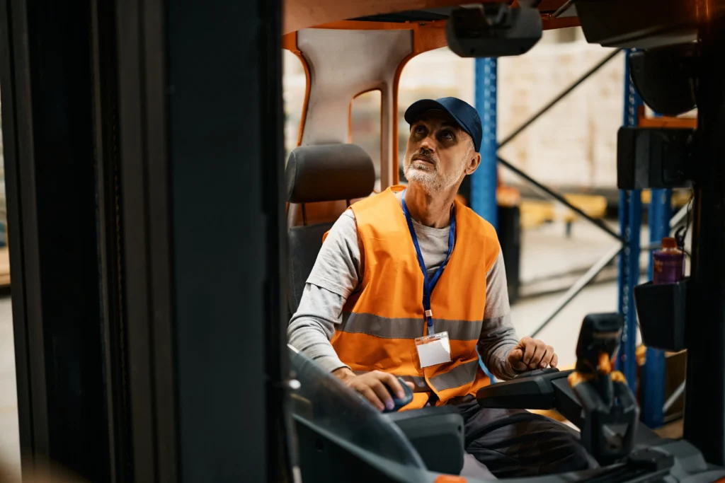 Forklift driver looking up at pallet racking